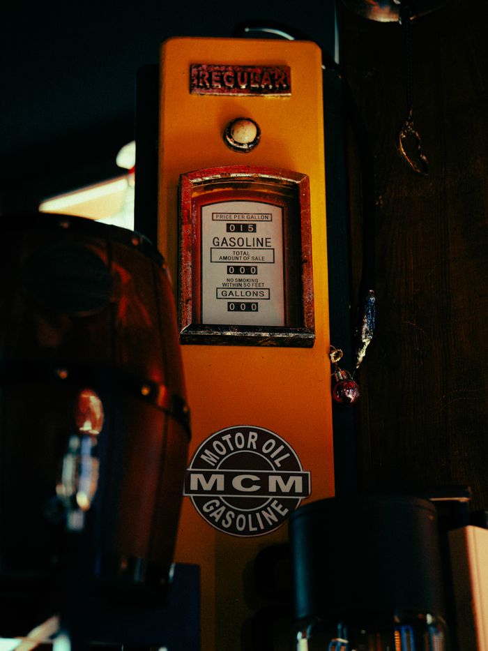 Close-up of a vintage gasoline dispenser at night with retro design and bright colors.
